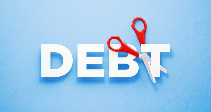 The word DEBT with a pair of scissors cutting through the T