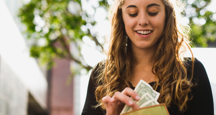 Teenage girl taking money from wallet